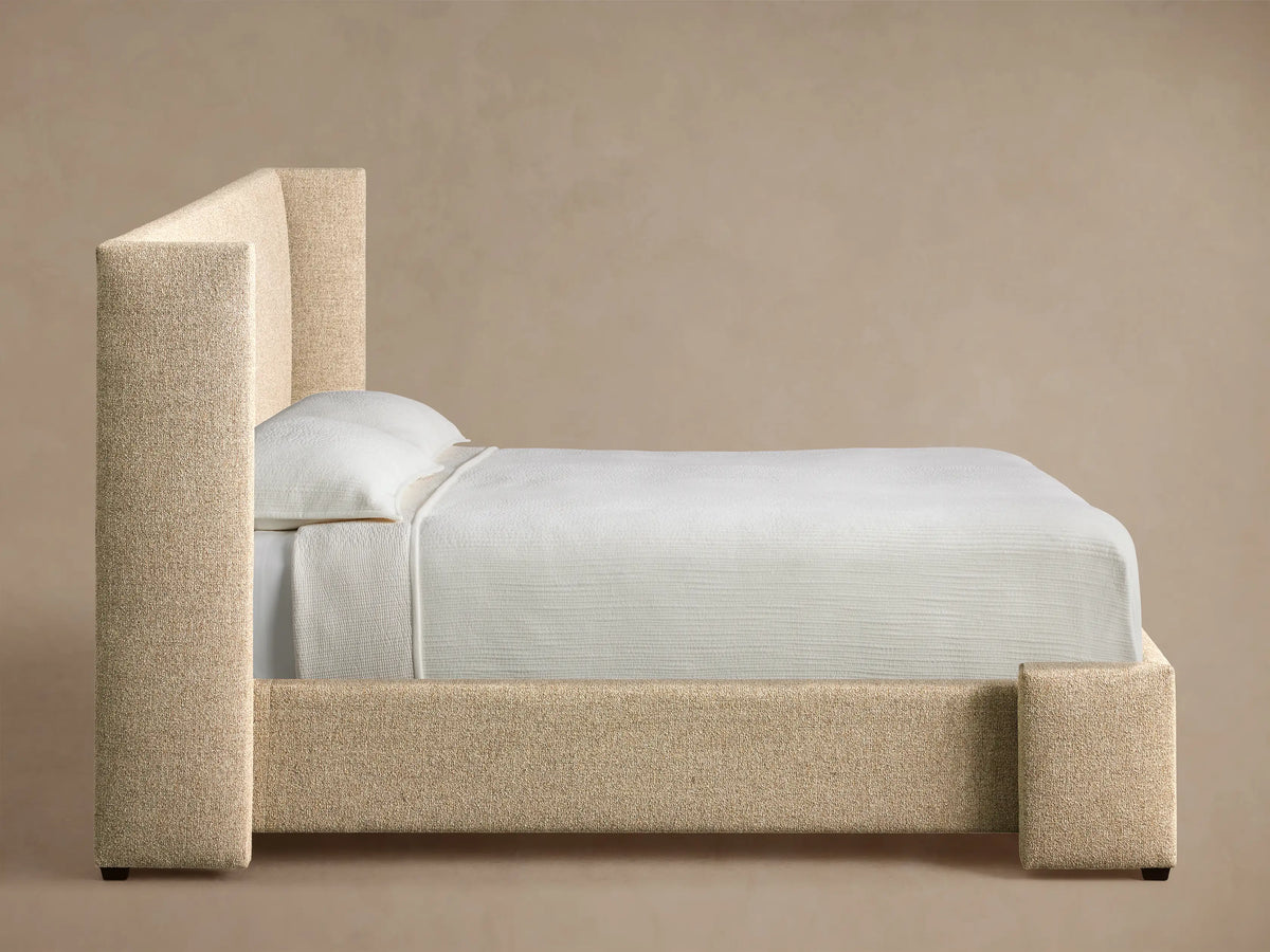 Close-up of the light beige textured upholstery on the Wyller Bed headboard.