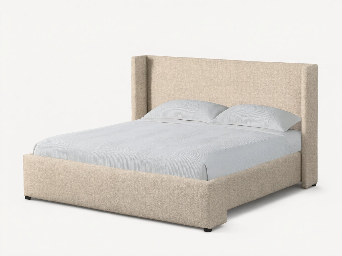 Front view of the beige upholstered Wyller Bed featuring an angled wingback headboard, made with white bedding.