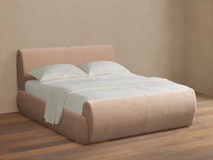 Wynn Bed: Light pink upholstered bed with rounded headboard, footboard & sides; white pillows & textured blanket; on wood floor.
