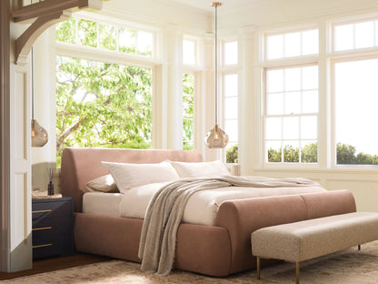 Wynn Bed: Light pink upholstered bed with rounded headboard, footboard & sides; white pillows & textured blanket; on wood floor.