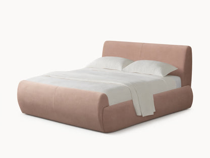 Wynn Bed: Light pink upholstered bed with rounded headboard, footboard & sides; white pillows & textured blanket; on wood floor.
