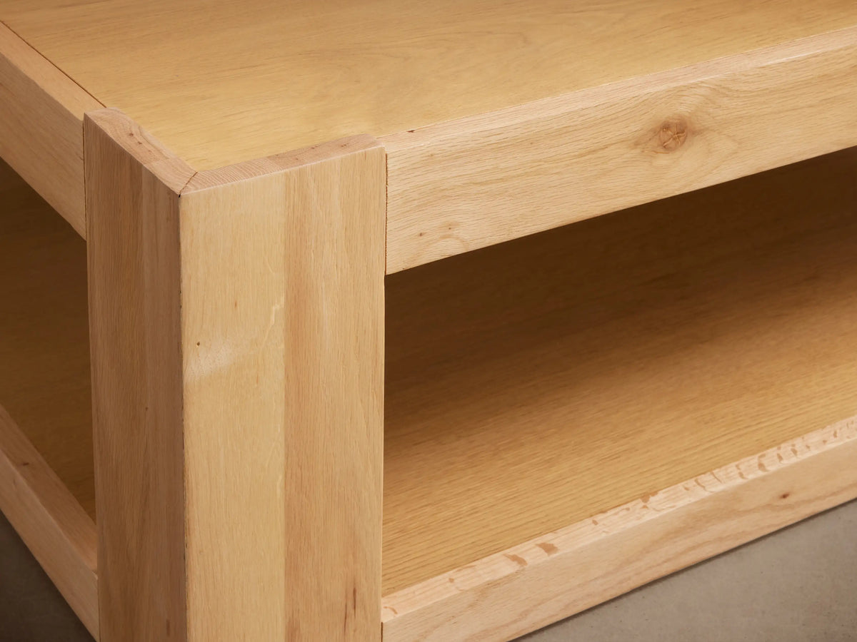 Devon Coffee Table: Square, light natural oak wood coffee table with a lower shelf, on a wooden floor.