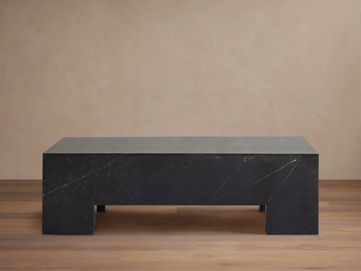 Brooklyn Coffee Table, rectangular block of dark black Marquina marble with white veining on a wooden floor.