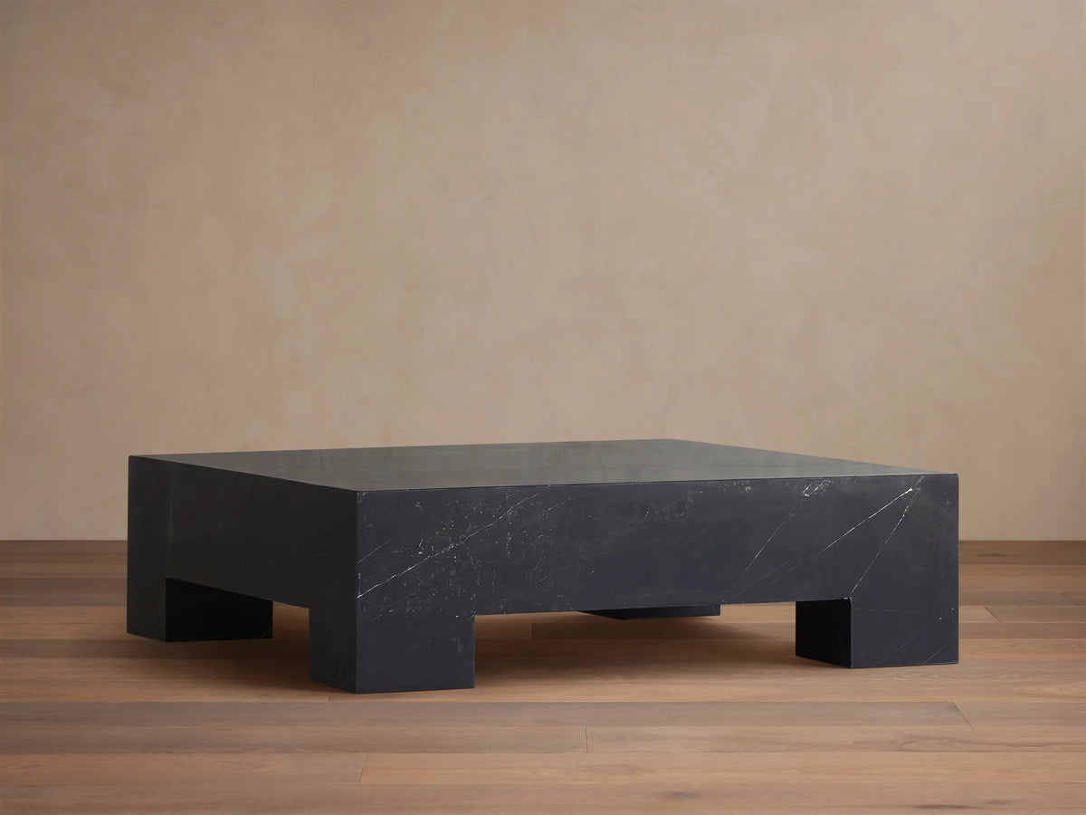 Brooklyn Coffee Table, rectangular block of dark black Marquina marble with white veining on a wooden floor.