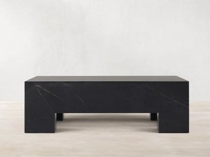 Brooklyn Coffee Table, rectangular block of dark black Marquina marble with white veining on a wooden floor.