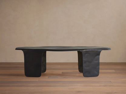 Melbourne Coffee Table, dark bronze metal, featuring an organic, wavy top and thick, sculpted legs on a wooden floor.