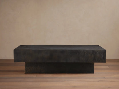 Sydney Coffee Table in a minimalist design, featuring a rectangular shape with a dark, textured finish, set on a hardwood floor.