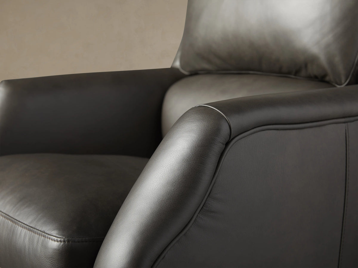 Alex Leather Desk Chair in dark Old West leather, high-back with cushion, 5-star wheeled base, front view on wood floor.