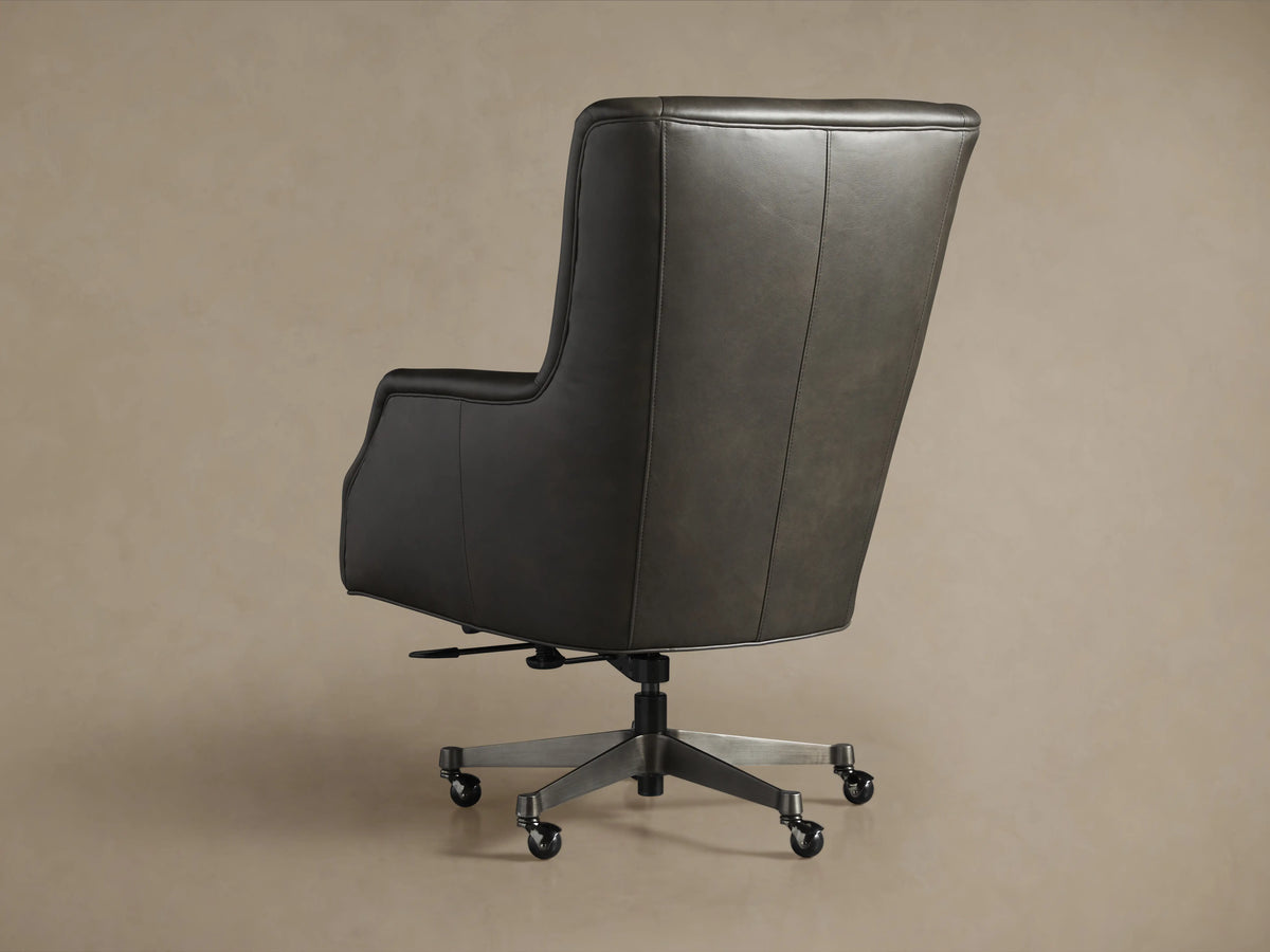 Alex Leather Desk Chair, dark gray leather, side view. Features a high back, armrests, and a five-star metallic base with casters.