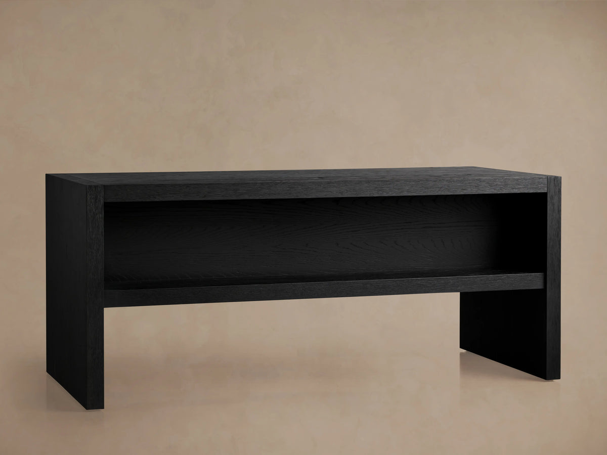 Close-up, angled view of Bodhi Executive Desk's black wire-brushed oak surface, showing a cord management slot.