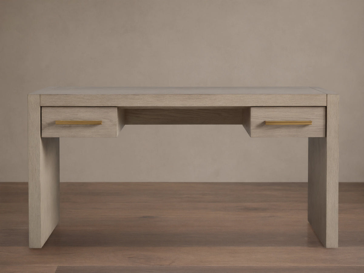 Bodhi Writing Desk, handcrafted light gray-brown wire-brushed white oak desk with two drawers and brass pulls, front view.