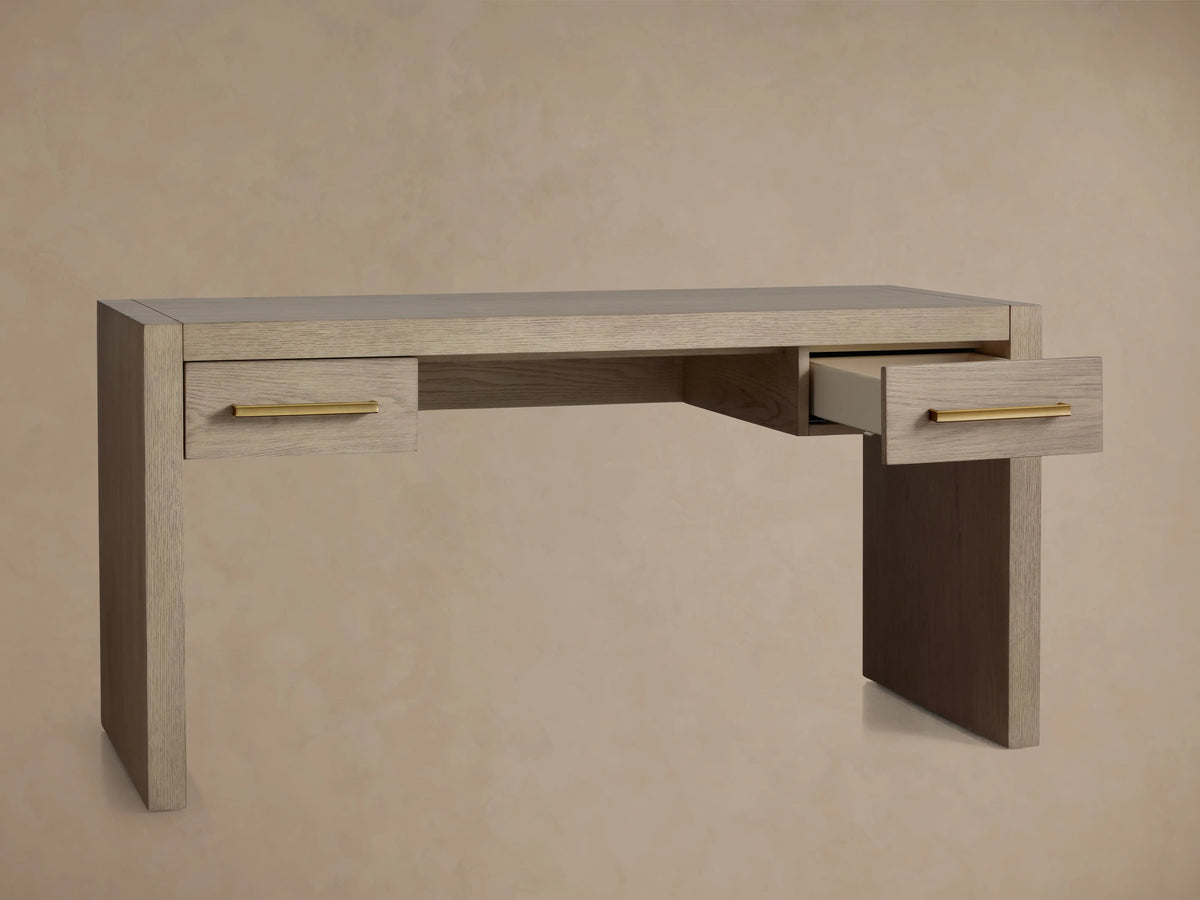 Light wire-brushed oak Bodhi Writing Desk with two drawers & brass pulls. One drawer is partially open, facing right.