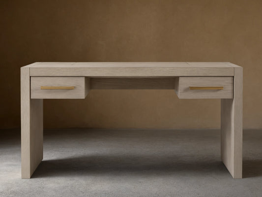 Bodhi Writing Desk, handcrafted light gray-brown wire-brushed white oak desk with two drawers and brass pulls, front view.