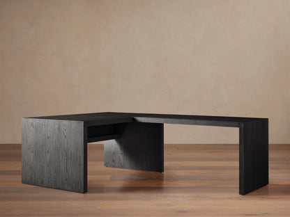 Bodhi Modular Desk, L-shaped, dark wire-brushed oak, 3 drawers with brass pulls, on wooden floor against a tan wall.