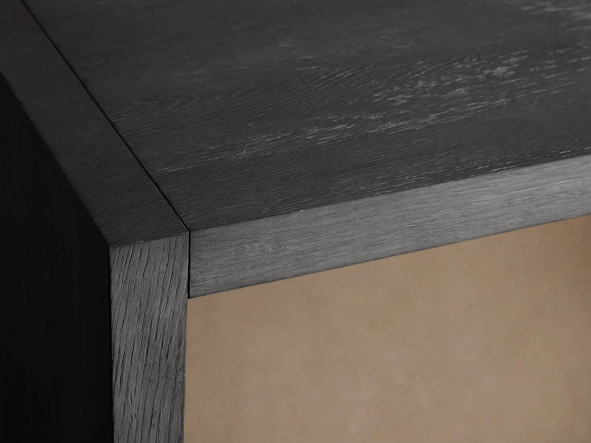 Close-up of Bodhi Modular Desk's dark wire-brushed finish with visible wood grain texture and a light-lined cord management slot.