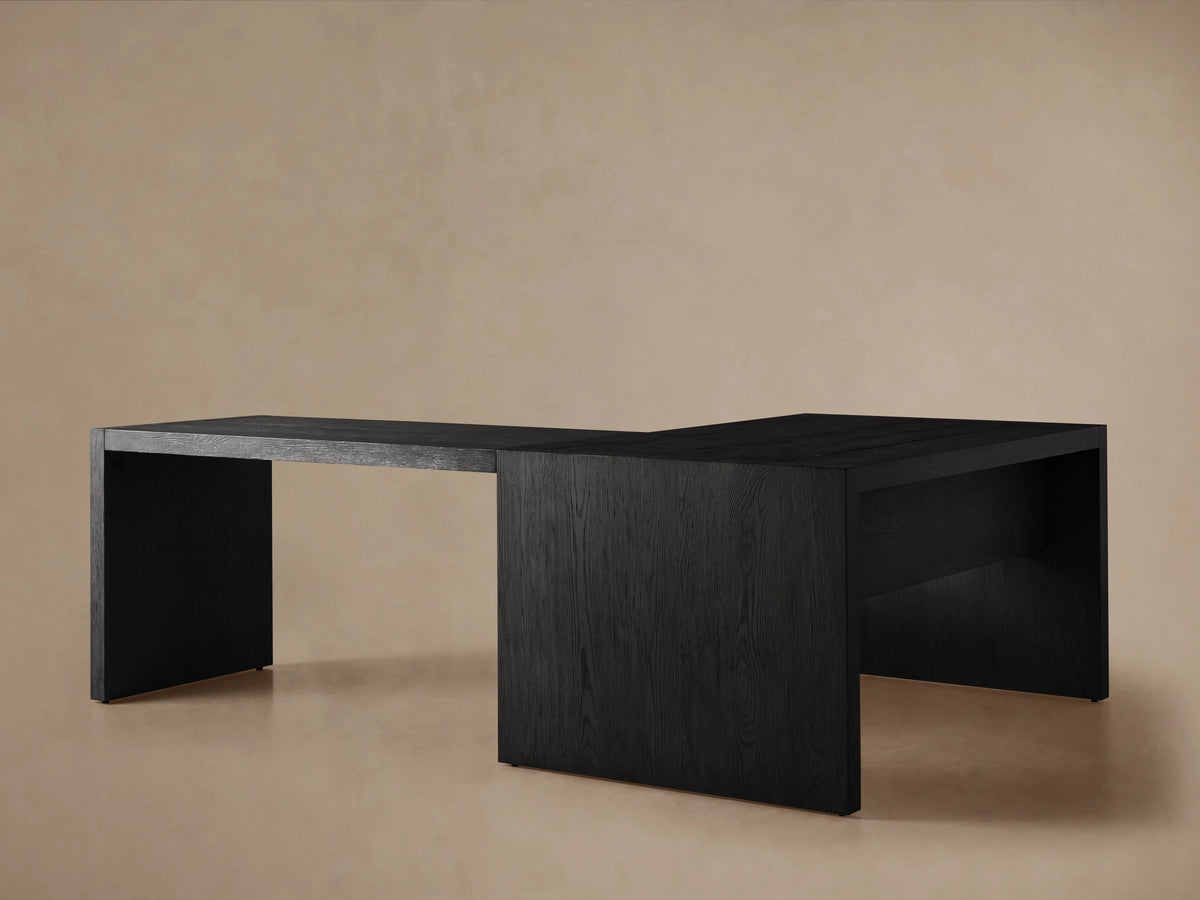 Bodhi Modular Desk corner, close-up of dark wire-brushed oak texture, visible wood grain & sharp joinery on tan background.