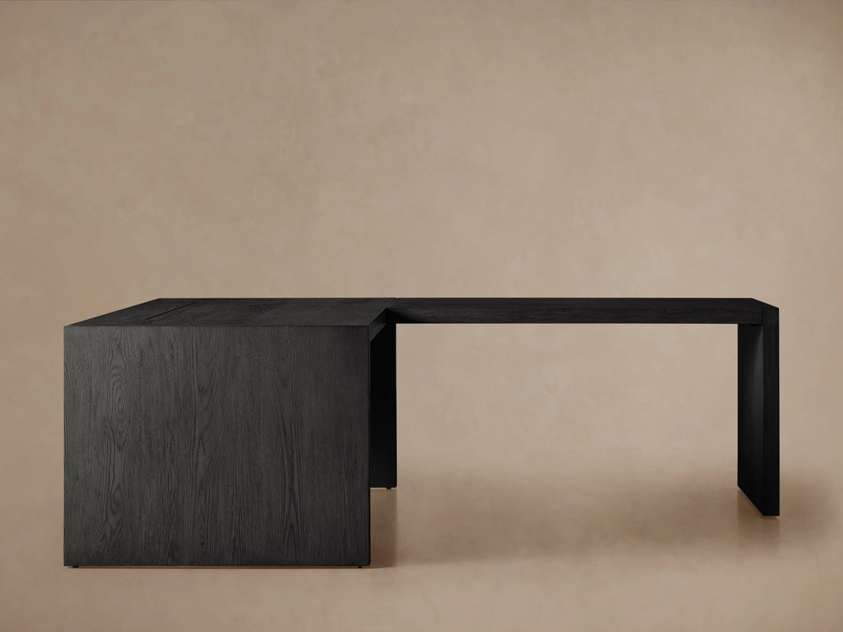 L-shaped Bodhi Modular Desk with Return Desk, black wire-brushed oak veneer, seen from front on light background.