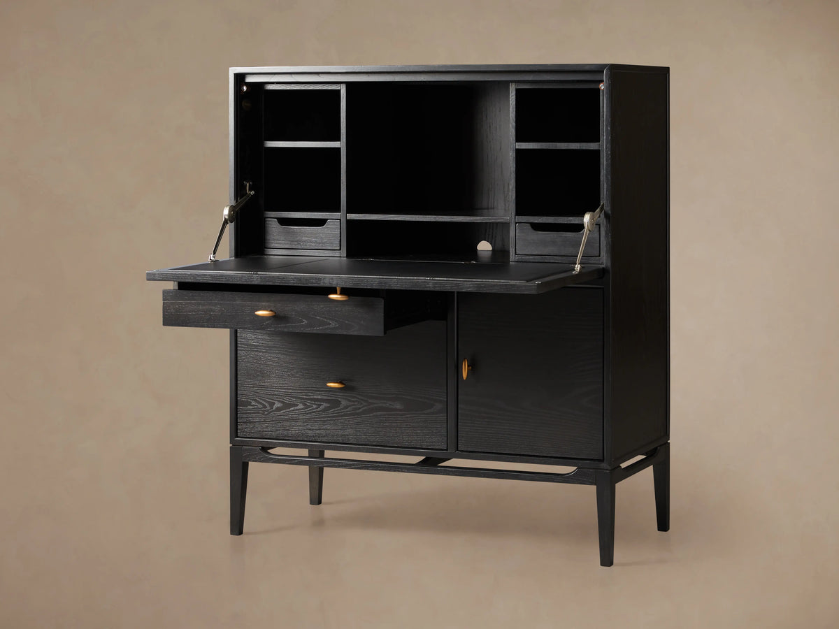 Brock Hideaway Desk made of dark ash wood with open top shelves, closed cabinet, leather writing surface, and slim wooden legs.