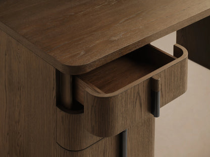 Front view of a dark brown wooden desk with three curved drawers, a long vertical dark handle, and a U-shaped leg.