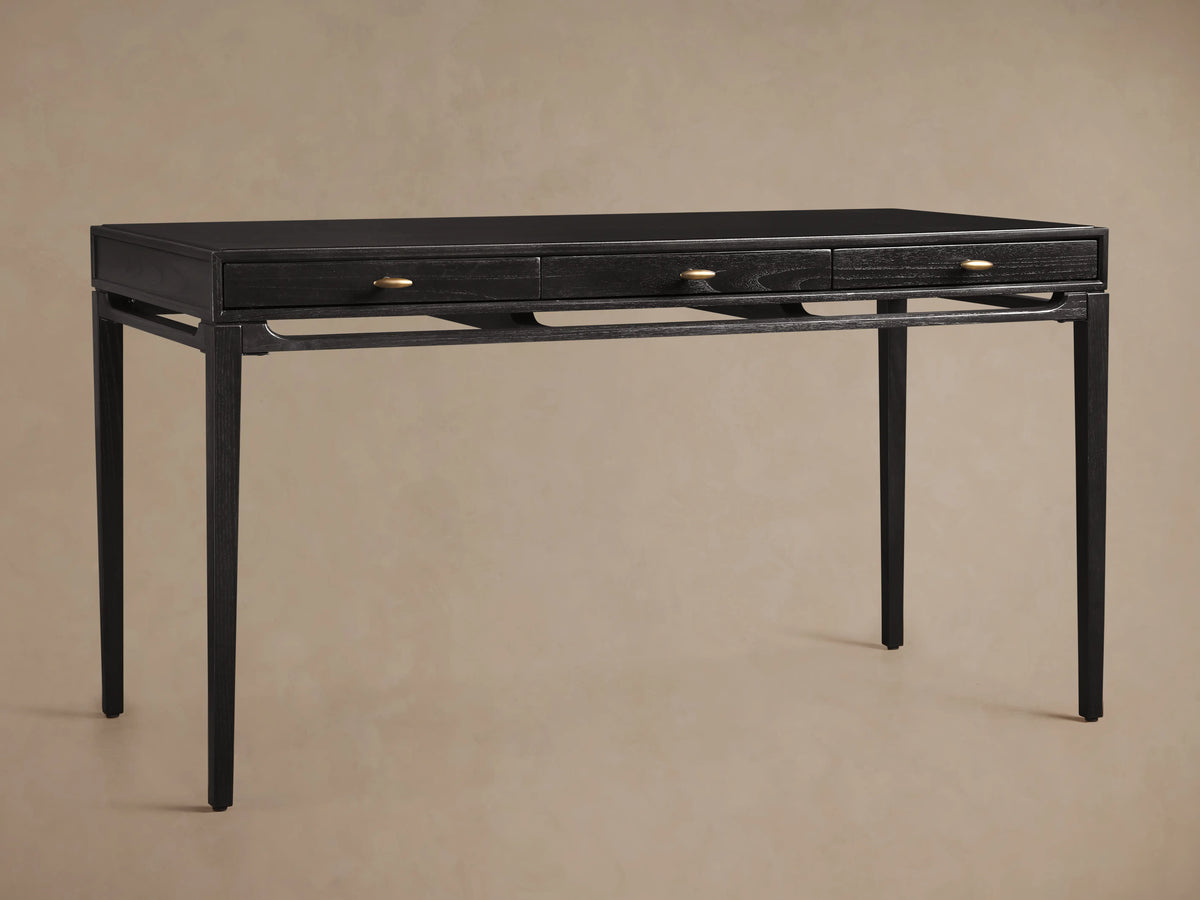Brock Writing Desk made of dark ash wood with slender legs and a smooth leather writing surface, featuring brass handles.