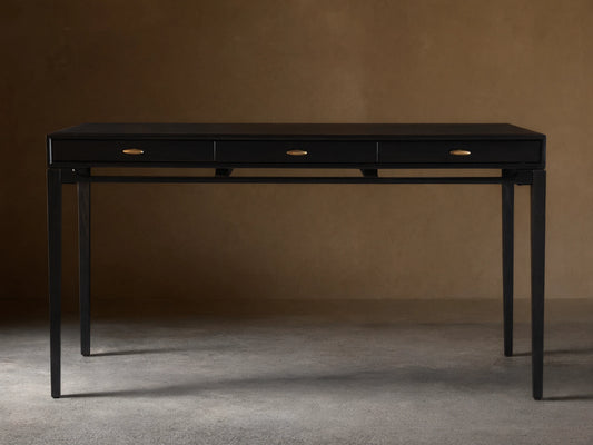 Brock Writing Desk with black finish, solid ash wood, three drawers with brass handles, and a leather writing surface.