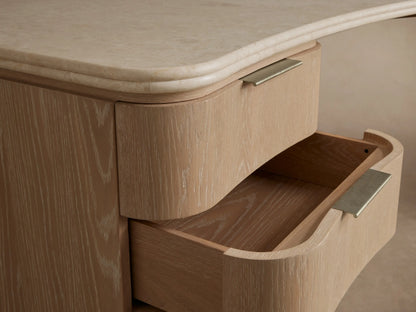 Caden Executive Desk with light oak veneer, a curved cream marble top, and 6 drawers with brushed nickel pulls.