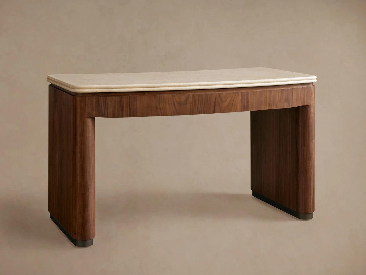 Close-up of Caden Writing Desk with curved walnut base, cream marble top with rounded edges. Drawer slightly open.