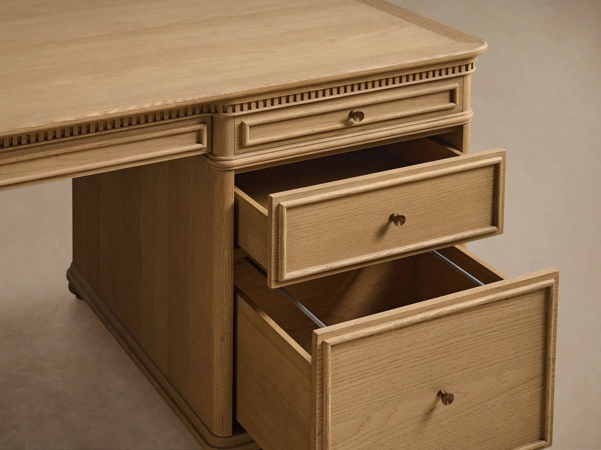 Carlisle Executive Desk, light oak with Marcona finish. Front view, rectangular top, dentil molding, 7 drawers with brass knobs, bun feet.