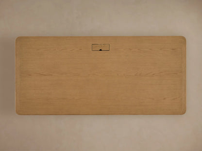 Carlisle Executive Desk in light Marcona oak, front view. Rectangular wood desk with dentil molding & bun feet.