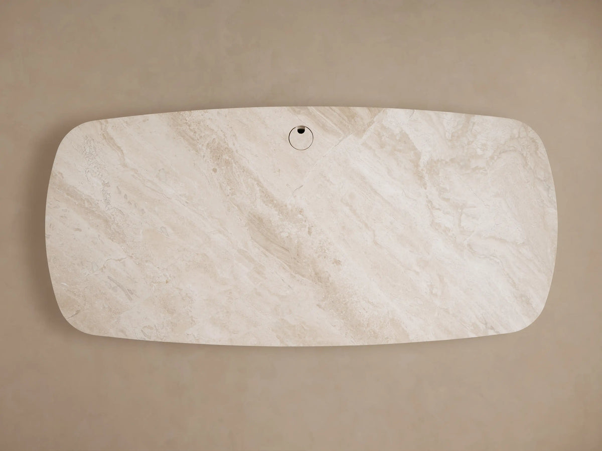 Front view of the Danny Executive Desk, with a light brown oak veneer frame, curved left side, central opening, and an oval royal cream marble top.