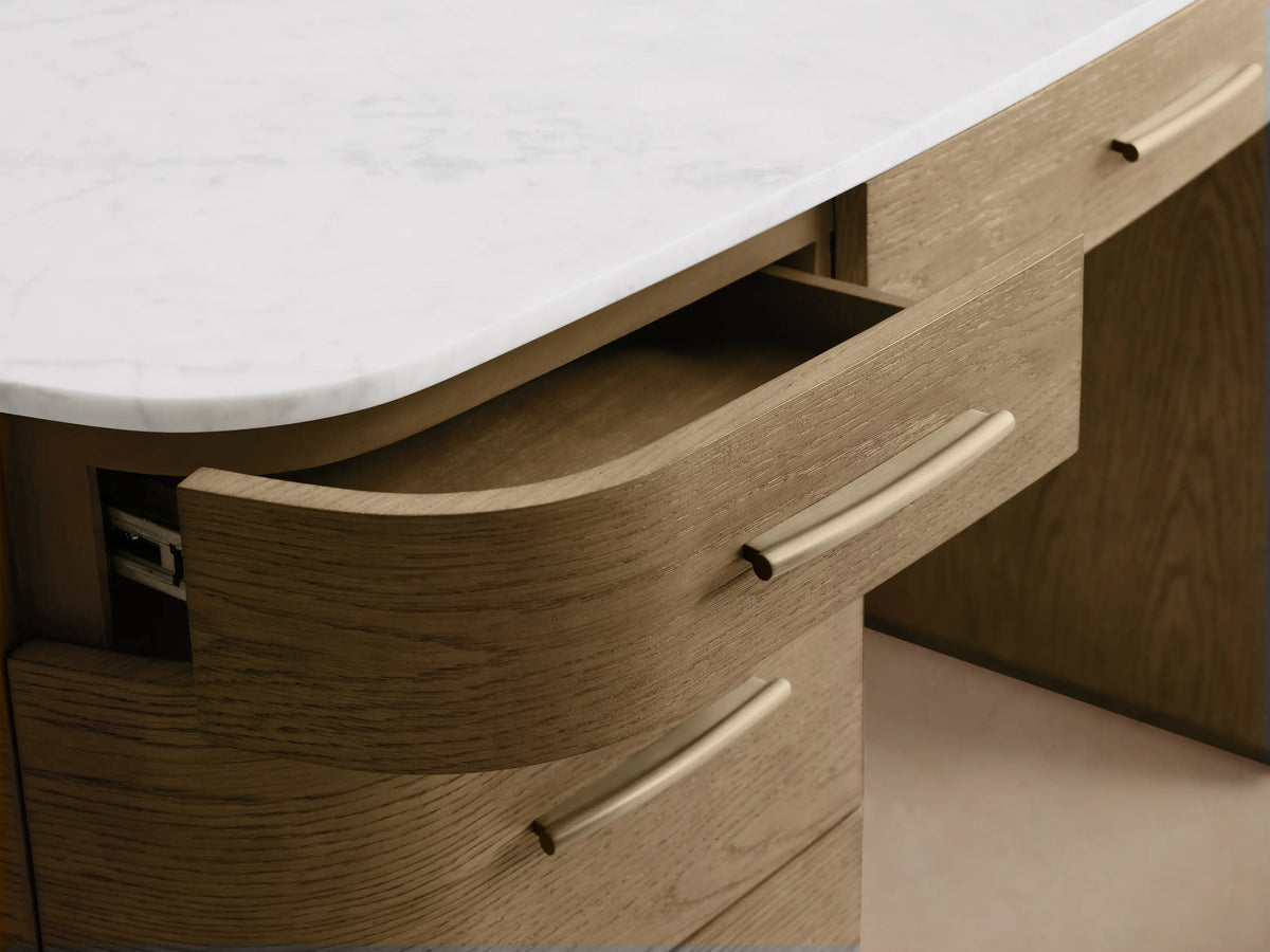 Front view of the Danny Executive Desk, with a white Carrara marble top, light oak veneer, and seven drawers with brass handles.