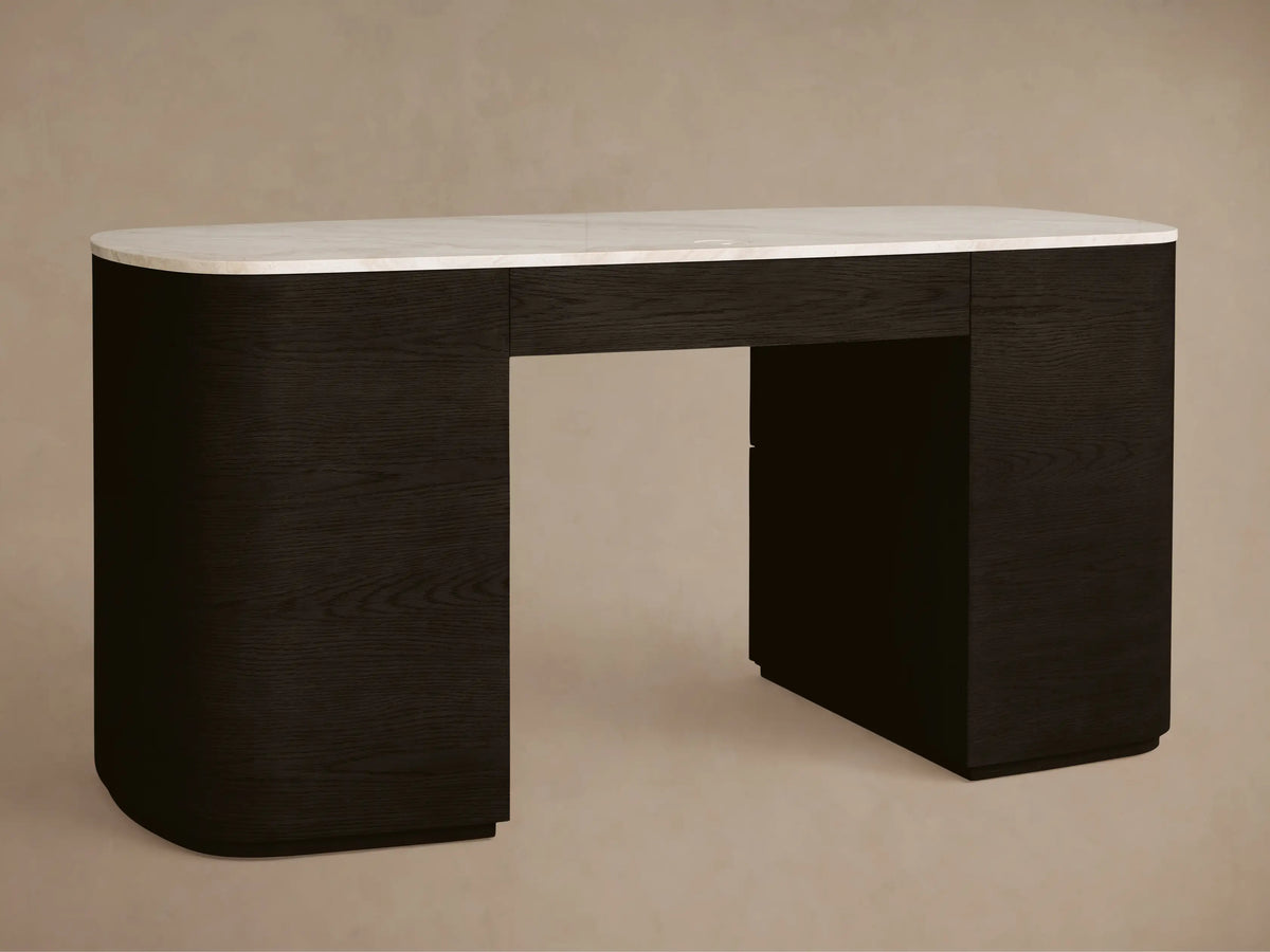 Close-up of Danny Executive Desk. Dark ebony wood with royal cream marble top, sculpted drawers, one slightly open, with brass handles.