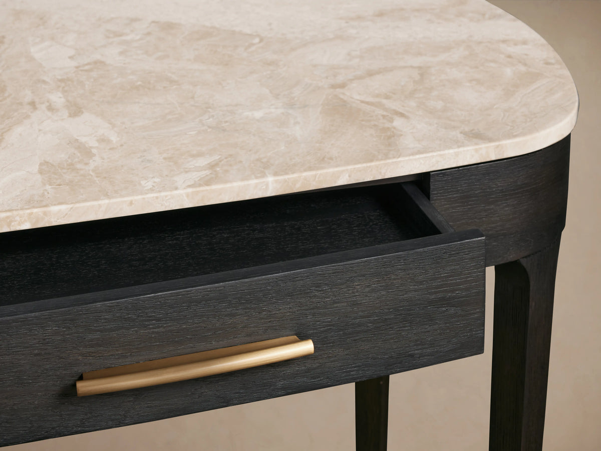 Danny Writing Desk with an earth-toned royal cream marble top, ebony wood finish, and partially open drawer with a brass pull.