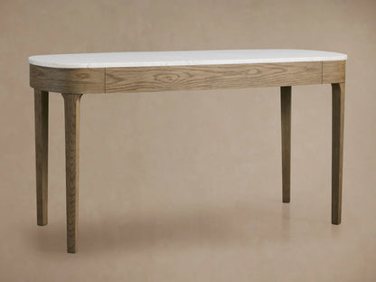 Danny Writing Desk: fawn oak veneer, oval white Carrara marble top, two drawers with brass handles. Front view on wood floor.