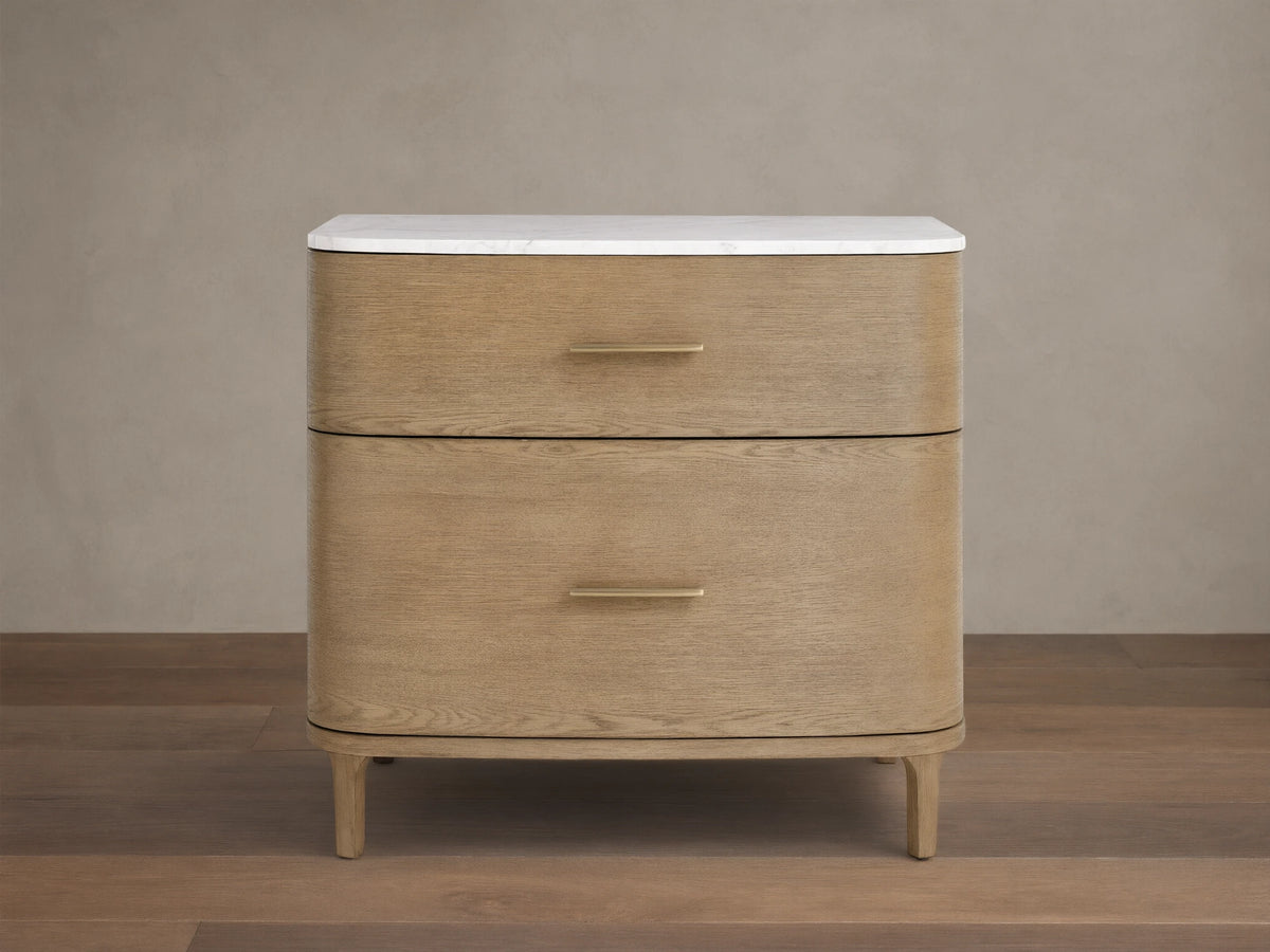 Front view of a light oak veneer Danny File Cabinet with two drawers, a white Carrara marble top, and brass-finished hardware.