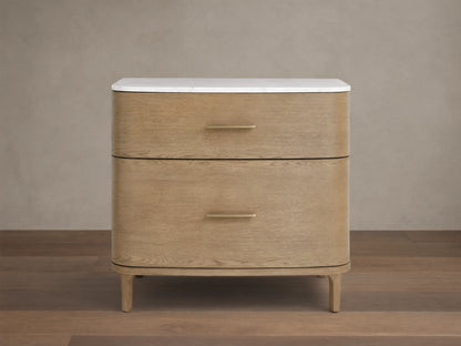 Front view of a light oak veneer Danny File Cabinet with two drawers, a white Carrara marble top, and brass-finished hardware.