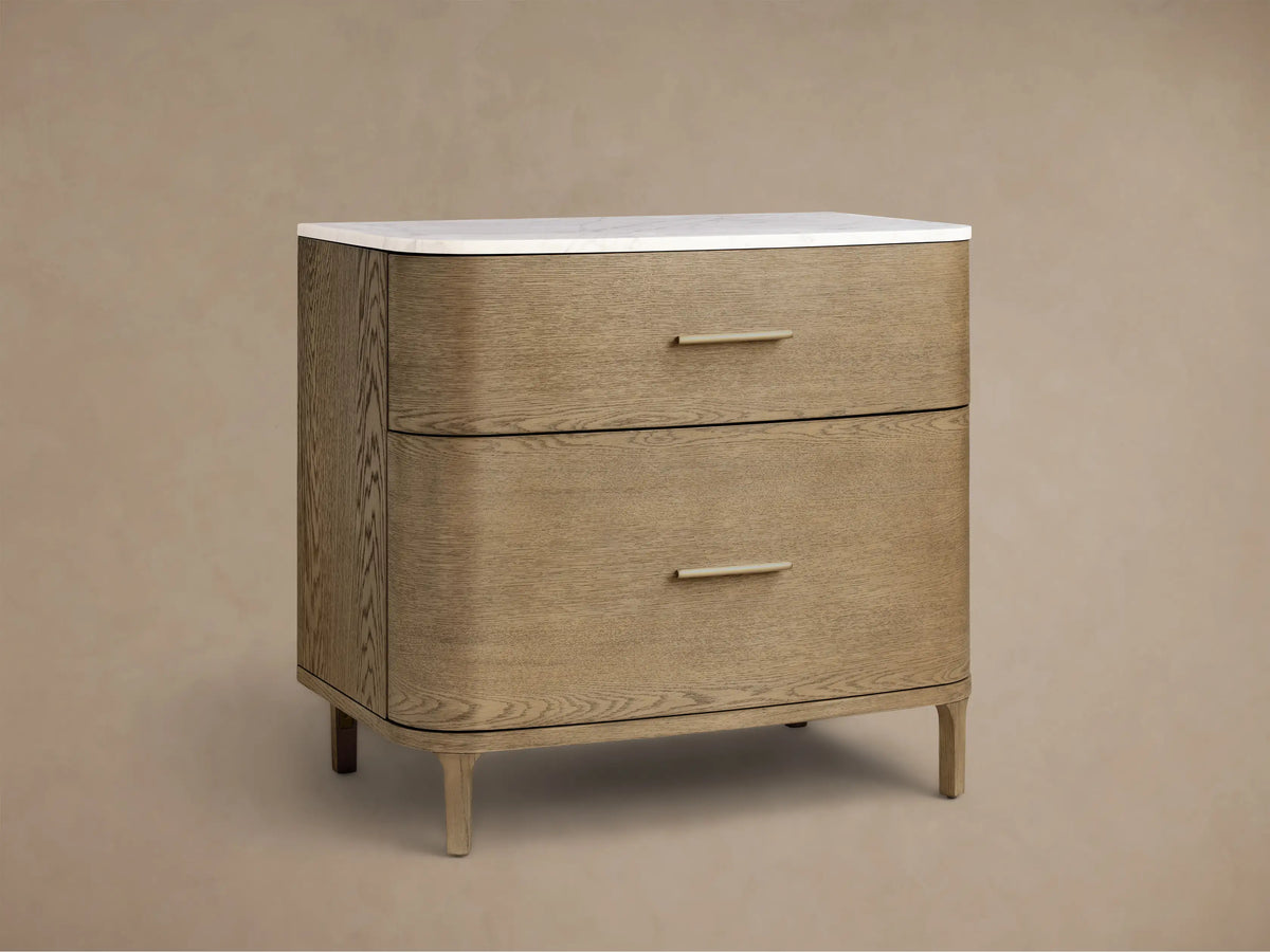 Front view of a light oak veneer Danny File Cabinet with two drawers, a white Carrara marble top, and brass-finished hardware.