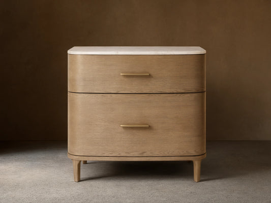 Front view of a light oak veneer Danny File Cabinet with two drawers, a white Carrara marble top, and brass-finished hardware.