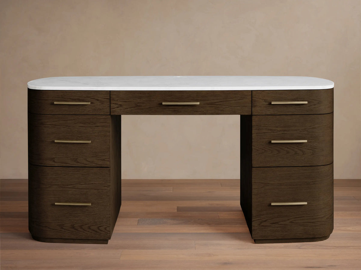Front view of the dark brown oak veneer Danny Executive Desk with a white Carrara marble top and seven drawers with brass handles.