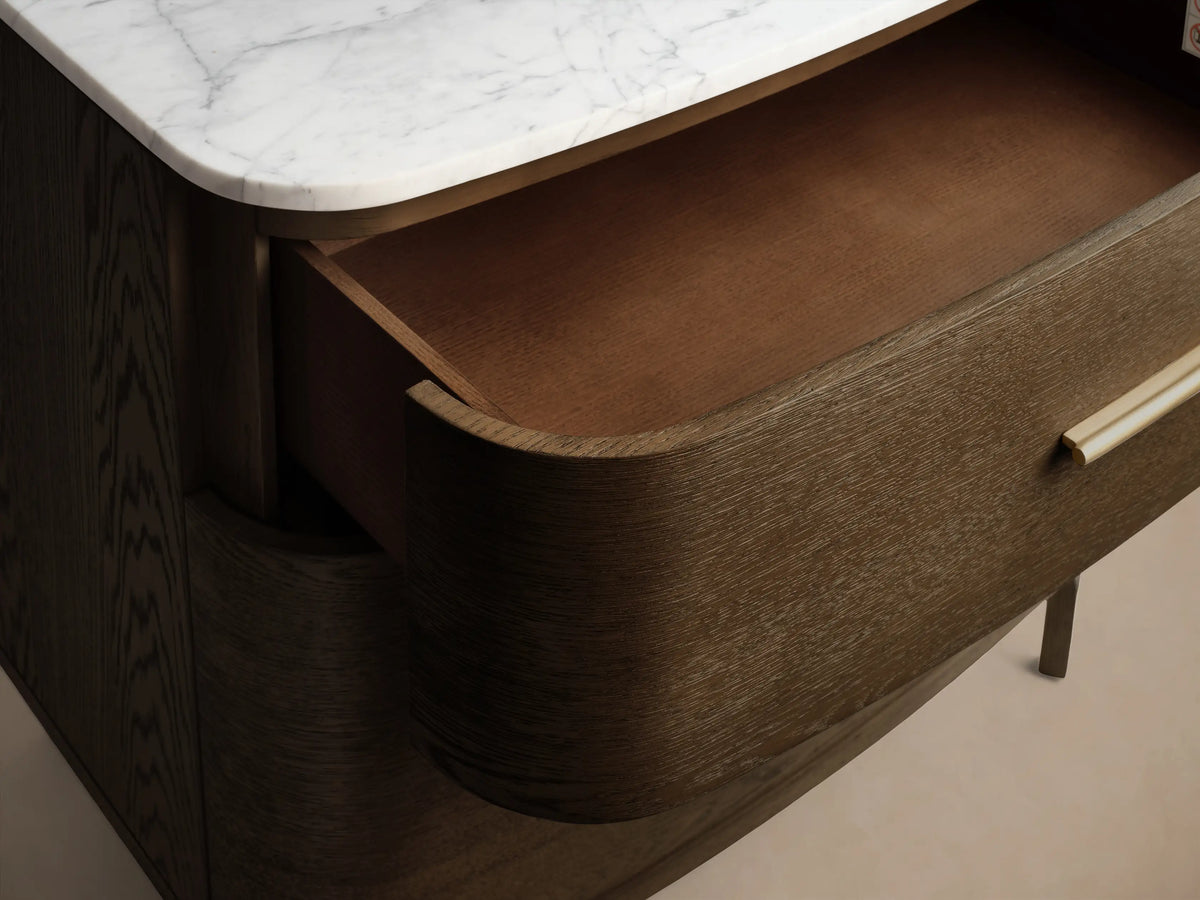 Front view of the Danny File Cabinet, dark brown wood, white Carrara marble top, two drawers with brass pulls, rounded corners, and tapered legs.