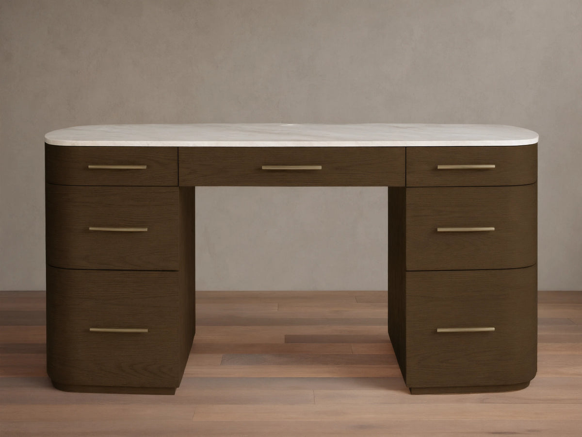 Front view of the Danny Executive Desk. It's a dark brown wood desk with a white Carrara marble top, brass pulls, and seven drawers.