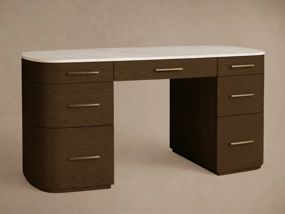 Front view of the Danny Executive Desk. It's a dark brown wood desk with a white Carrara marble top, brass pulls, and seven drawers.
