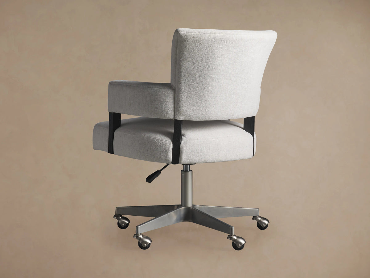 Fallyn Desk Chair in light fabric with padded armrests, cushioned seat, and backrest on a metal swivel base with casters.