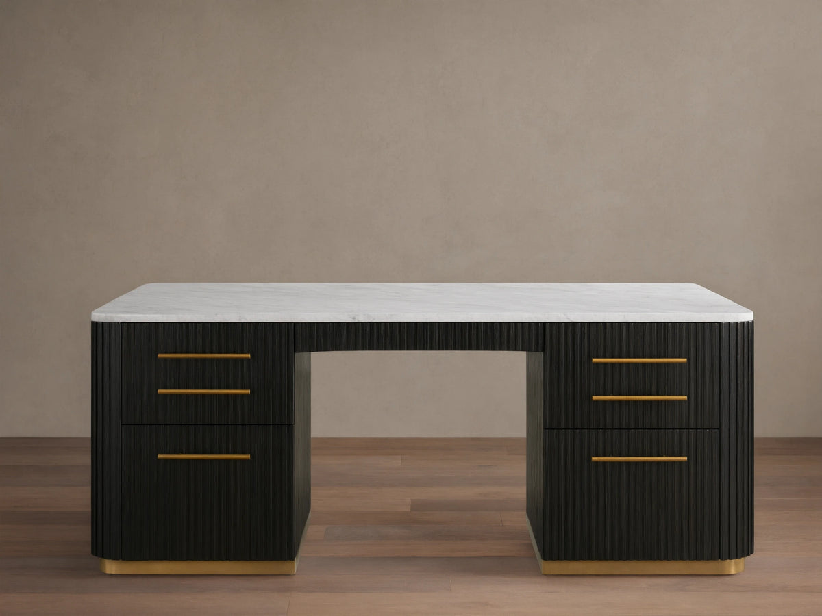 Finnley Executive Desk with dark wood finish, brass handles, six drawers, and a white surface, set on wood floor.