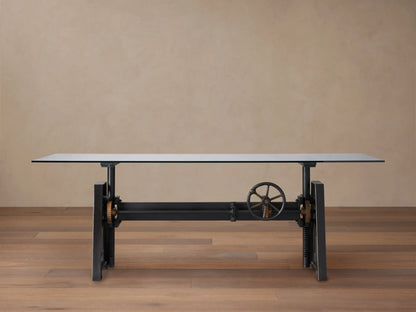 Industrial Crank Desk with a sleek glass top, supported by a sturdy black rubbed copper base and visible crank mechanism.