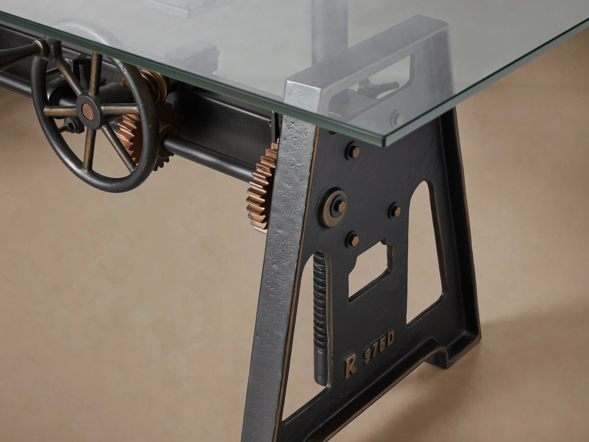 Industrial Crank Desk with a rectangular tempered glass top on a large black rubbed copper base featuring a central crank mechanism.