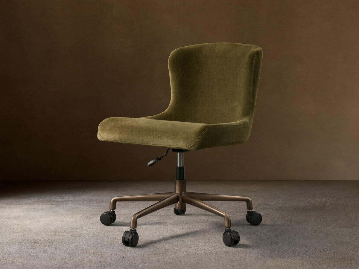 Kirsten Desk Chair, green velvet upholstery with a curved back, on a dark brown powder-coated aluminum base with 5 casters.