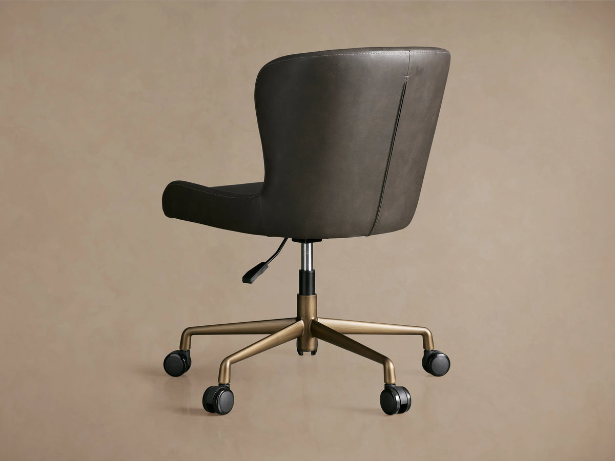 Kirsten Faux Leather Desk Chair in dark brown, featuring a curved back, gold aluminum base with casters, and hydraulic lift handle.