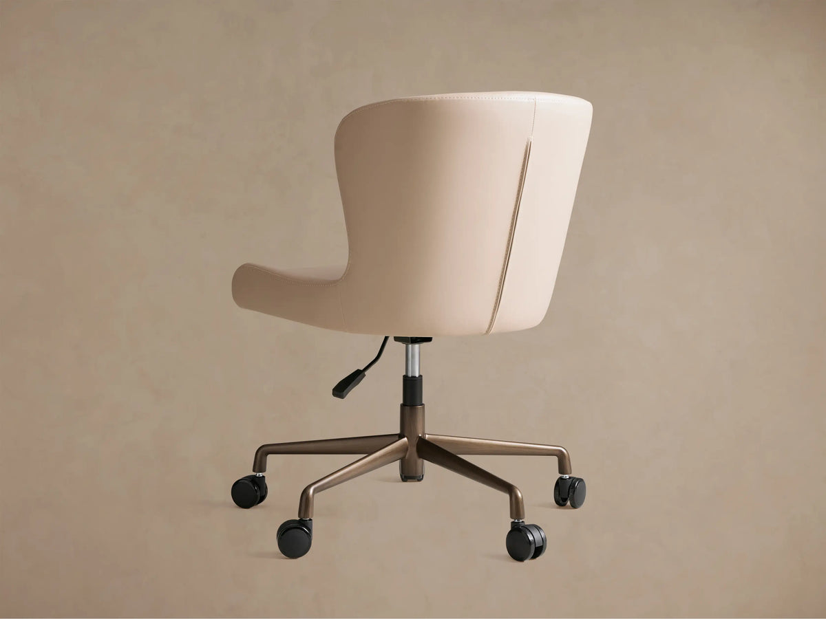 Kirsten Faux Leather Desk Chair, angled close-up of cream faux leather seat and curved back with detailed stitching.