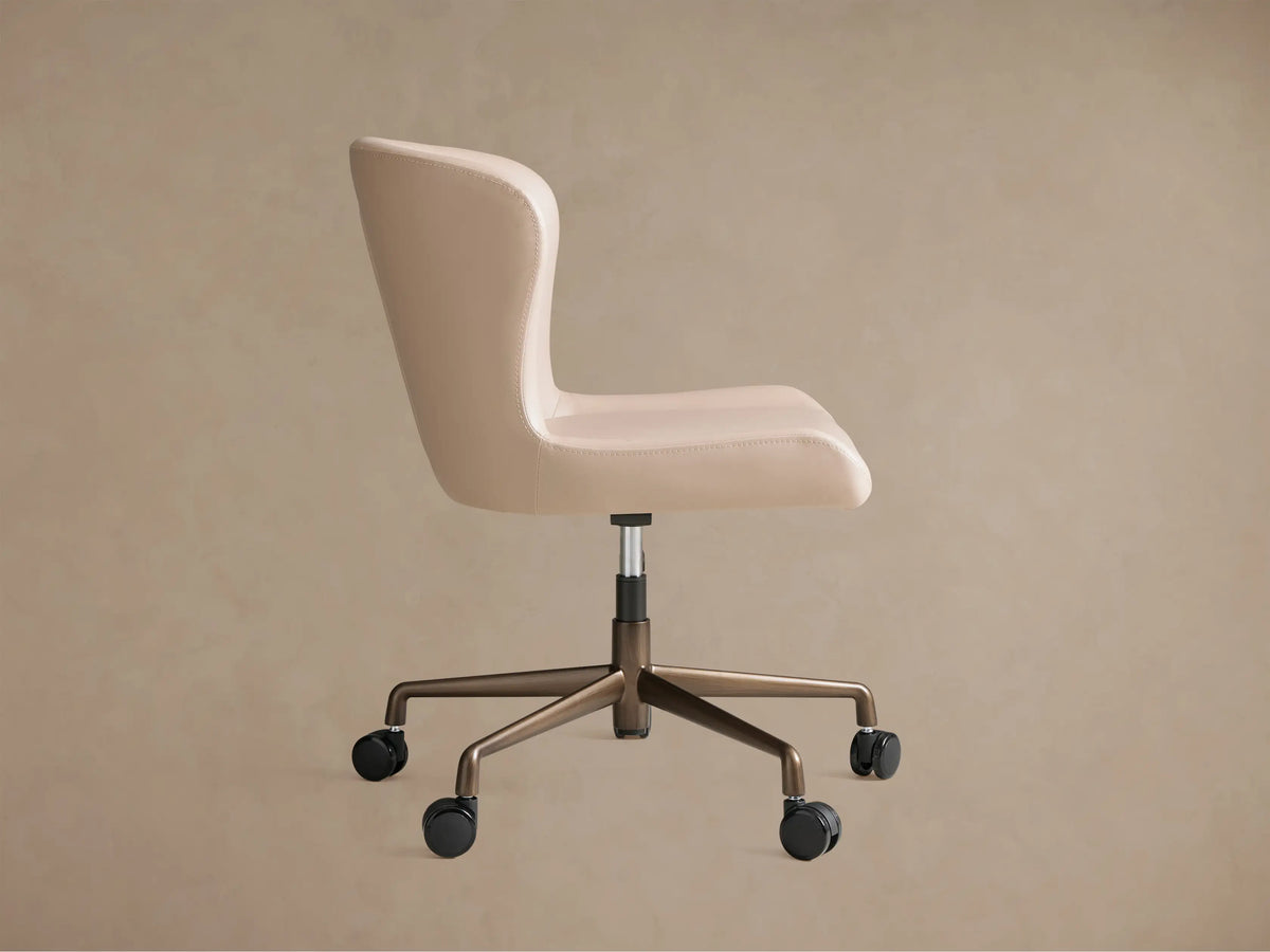 Back view of a light beige Kirsten Faux Leather Desk Chair with a bronze 5-star caster base and a vertical seam detail.